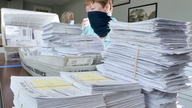 Barnstable Town Clerk Ann Quirk is surrounded by a growing pile of applications for mail-in ballots at her office on Thursday. Quirk said they have already received nearly 5,000 applications from people looking to vote in this year's primary and presidential elections.