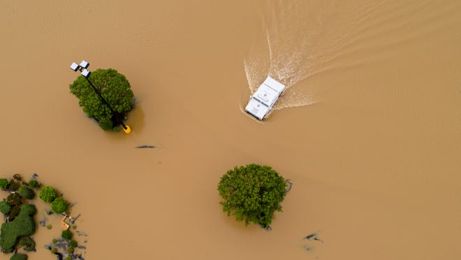 An Arkansas State trooper drives through the Wal-Mart parking lot in a humvee on May 3, 2017, in the heavily flooded East Pocahontas, Ark.