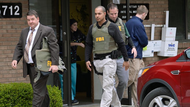 FBI agents leave the office of Dr. Fakhruddin Attar at the Burhani Clinic in Livonia, Michigan. Friday, April 21, after completing a search for documents. The investigation is connected to the case of Dr. Jumana Nagarwala, of Northville, charged with performing genital mutilation on two young girls from Minnesota.