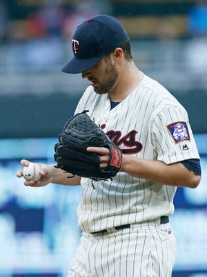 Minnesota Twins pitcher Phil Hughes looks at the ball following a mound visit after he gave up two home runs for three runs by the Baltimore Orioles in the fourth inning of a baseball game Wednesday, May 11, 2016, in Minneapolis. (AP Photo/Jim Mone)