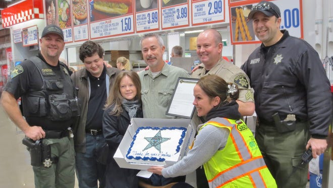 John Borgman, center, is honored by Marion County Sheriff's deputies on Dec. 29, 2016, at the Salem Costco where he works as a checker.