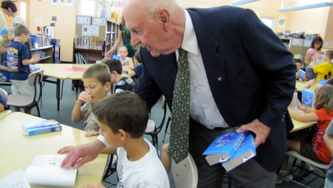 Bob Pityo of the Cedar Grove Rotary Club supplies Eric Turi, a third-grader at South End School, with a dictionary in 2010. The Rotary Club handed out dictionaries to each third-grade class in Cedar Grove schools.