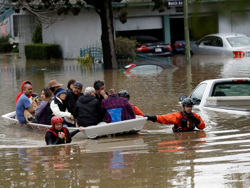 Rescue crews take out residents from a flooded neighborhood on Feb. 21, 2017 in San Jose, Calif. Rescuers chest-deep in water steered boats carrying dozens of people, some with babies and pets, from a San Jose neighborhood inundated by water from an 