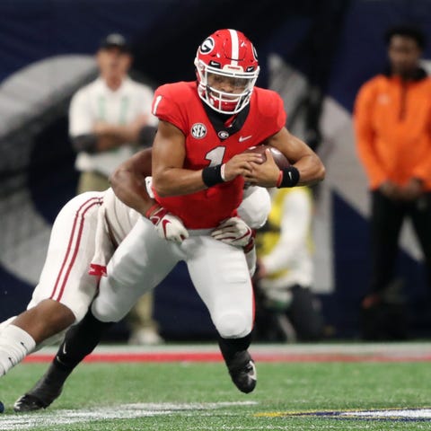 Georgia quarterback Justin Fields runs the ball...