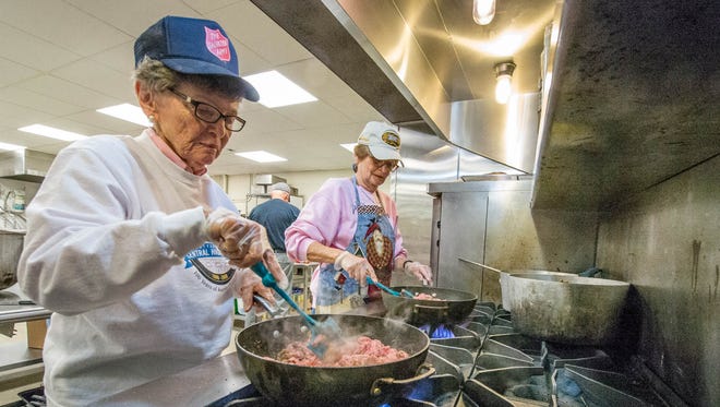 Volunteers Melva Zaharion, left, and Nancy Chapman brown some hamburger meat for spaghetti sauce at The Salvation Army's soup kitchen in Battle Creek.