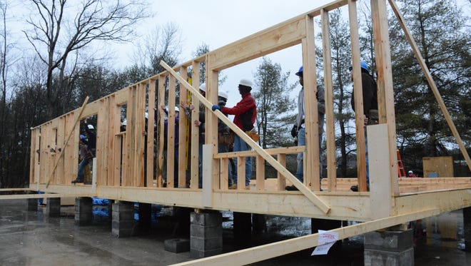 Broome-Tioga BOCES students raise the first wall of a Broome County Habitat for Humanity home they are building Wednesday.