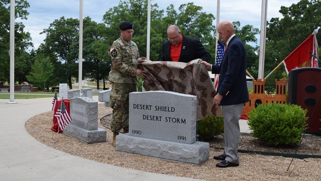 Brig. Gen. James Raymer, U.S. Army Engineer School commandant, left, Master Sgt. (retired) Bruce Harmon, center, and Lt. Gen. (retired) Daniel Schroeder unveil a stone commemorating Desert Shield and Desert Storm during a ceremony Friday in Soldier Memorial Grove.