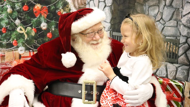 Ava Baker shared a laugh with Santa Claus during a recent holiday open house at the Union County Public Library. Children from all over the county came to visit Santa Claus and take part in other activities.