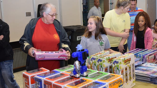 Katelyn Jones (right), smiles at her grandmother Evelyn Mullins as they look for a gift Saturday at the Doll  Toy Fund distribution site located at City Hall. The Doll & Toy Fund is sponsored by the Alexandria Rotary Club and The Town Talk. Dolls and toys were distributed to parents and children with volunteers from The Town Talk and The Rotary Club serving as guides.