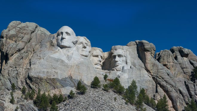 Mount Rushmore set against a bright cloud free blue sky.