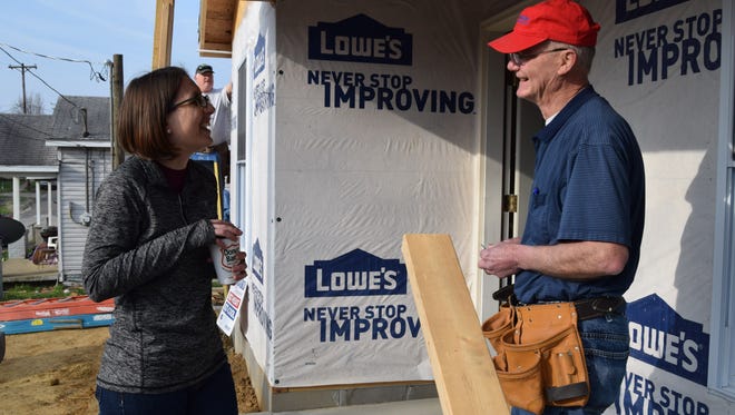 Habitat for Humanity Director Britney Smith talks to David Butler, a Habitat board member and volunteer, at the build site of a Habitat home.