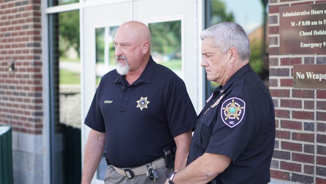 Henderson County Sheriff Charles McDonald and Buncombe County Sheriff Jack Van Duncan speak to members of the press in front of the Henderson County Sheriff's office Saturday.