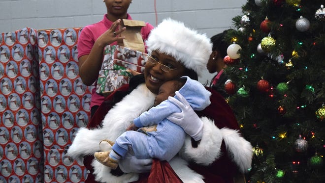 LaRhonda Jess, who played Mrs. Claus during Soul Santa, holds 2-month-old Justin Harris on Dec. 16.