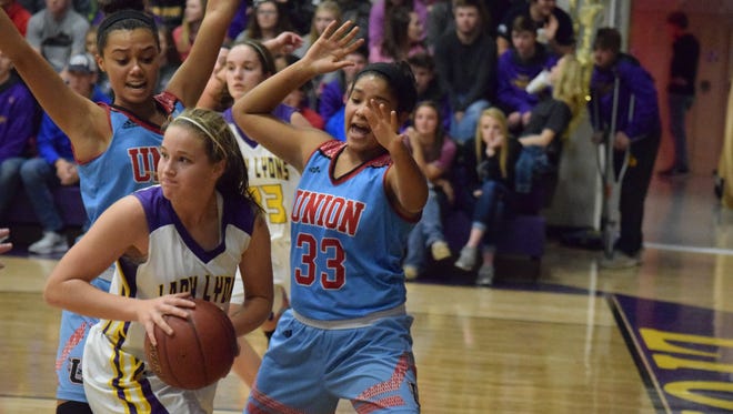 Jocelyn Spaulding and Raigan Price surround Lyon County's Lulu Taylor during the game Friday night.