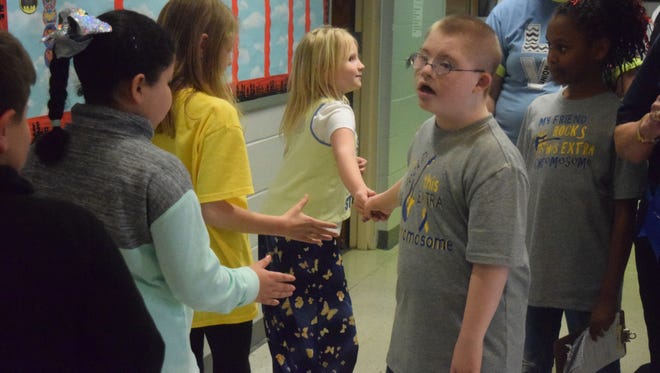Luca Marsh shakes hands with several of his classmates during the walk around the school.