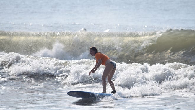 Kathy Horst, 36, catches a waves during the Ladies Longboard competition. Horst began surfing at Assateague State Park three years ago and now travels regularly from her home in Lancaster, Pennsylvania, to surf on the Eastern Shore.
