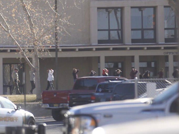 Students are led out of Aztec High School Thursday