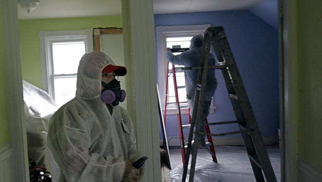 Contractor Luis Benitez cleans up lead paint in a contaminated building in Providence, R.I.
