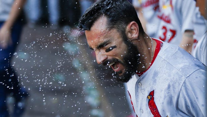 St. Louis Cardinals’ Matt Carpenter cheers after being splashed with a cup of water for hitting a ninth-inning HR Sunday.