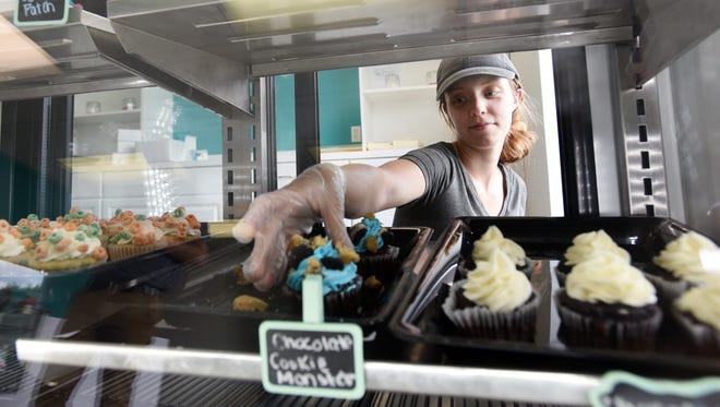 Linda Sprankle reaches for a chocolate cookie monster cupcake at Linda's Sweets on Linden Avenue in Zanesville.