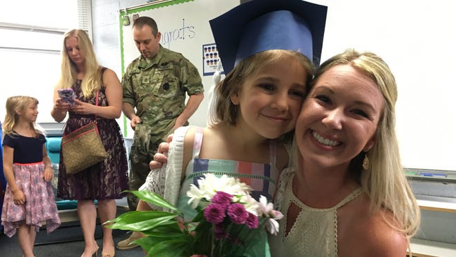 Kindergarten teacher Lauren Zaleski gets a last-day hug from Alanna Hamilton.