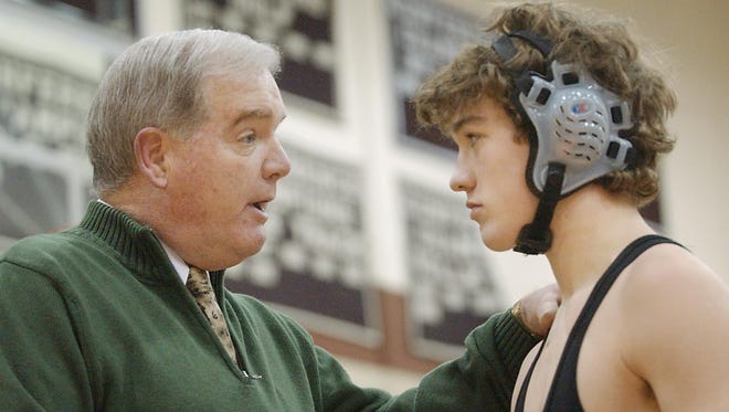 Jack Holloway talks with Tower Hill wrestler Ian Lonsdale during a match on the way to Holloway's 300th coaching win in 2006.