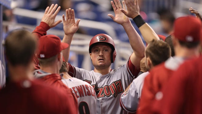 Jordan Pacheco of the Arizona Diamondbacks is congratulated in the dugout after scoring during the second inning of a game against the Miami Marlins at Marlins Park on May 21, 2015, in Miami.