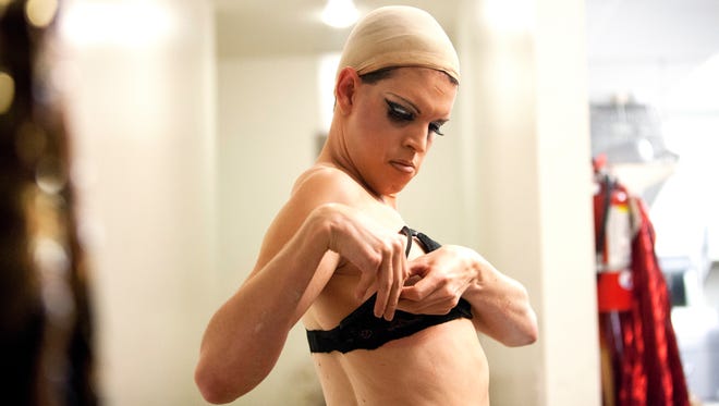 Andrew Lawrence, 30,  who performs as a female illusionist Audri Fenmore, puts on a bra before getting dressed for his first act during a production he produced called Audri Fenmore's "Some Like It Hot," a summertime variety show at Avagradro's Number June 27, 2014.