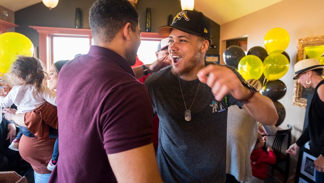 Port Huron High School graduate and Central Michigan wide receiver Mark Chapman, right, greets his cousin Winslow Chapman at his draft party at Pompeii's in Port Huron Friday, May 4. Mark was selected No. 1 overall in the Canadian Football League draft by the Hamilton Tiger-Cats.