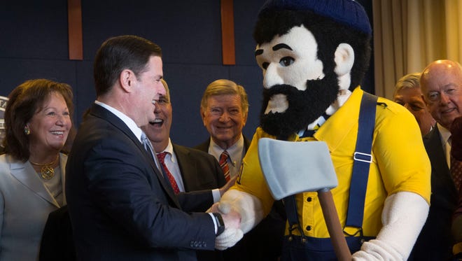 Gov. Doug Ducey shakes Louie the Lumberjack's hand during a his signing of House Bill 2547 at the Governor's office on May 22, 2017.