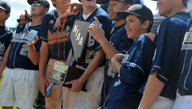 The Virginia City Muckers baseball team holds up the NIAA Division IV trophy after winning the title on Saturday.