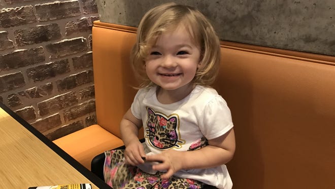 Isabella is all smiles as she graduated from a high chair to a booster seat while out to lunch recently.