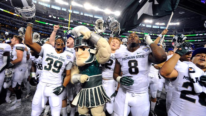 The Spartans celebrate after MSU's come-from-behind 42-41 victory over Baylor in the Goodyear Cotton Bowl Classic.