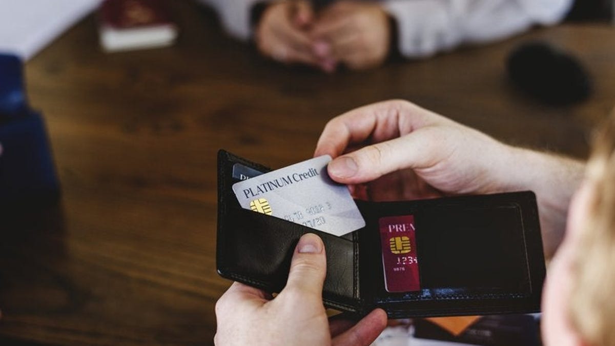 Hand pulling credit card out of wallet