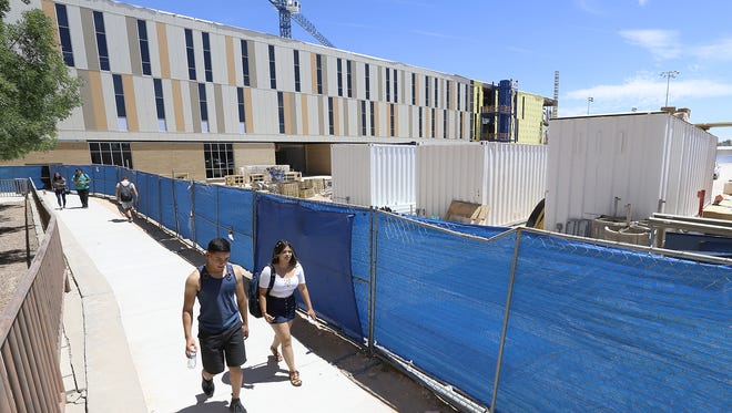 Eastwood High School students make their way between classes Thursday through a construction zone. The new three story school, background has portions which are now complete including the science wing and fine arts wing. 