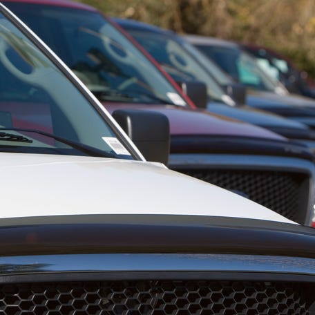 A row of new trucks at a dealership.