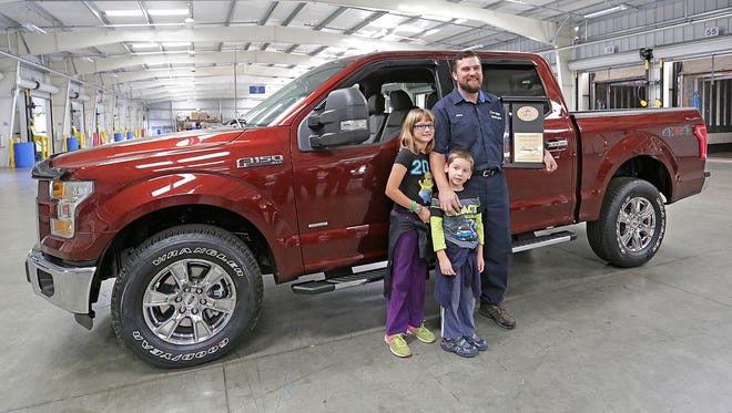 Con-way Freight truck driver Jeremy Steger of Plymouth, stands in front of his new Ford F-150 Pickup truck, with his kids Leah and Adam. The 17 year driver was awarded the truck by Con-way after he took first in the "Straight Truck class" at the 2015 National Truck Driving Championships, beating out 50 other drivers. Tuesday October 6, 2015.