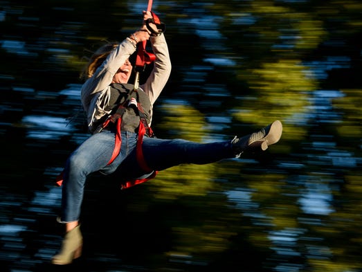 Donna Mauer, of Orlando, Fla., rides a zipline in the