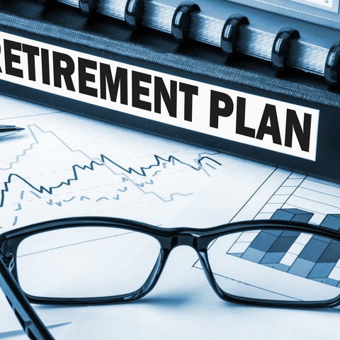 Binder labeled retirement plan, set amid glasses, 