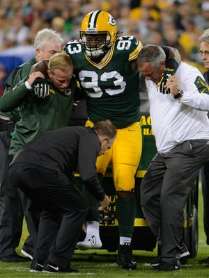 Green Bay Packers defensive end Josh Boyd (93) is helped up to a cart by the medical staff during a September 2015 game against Seattle.
