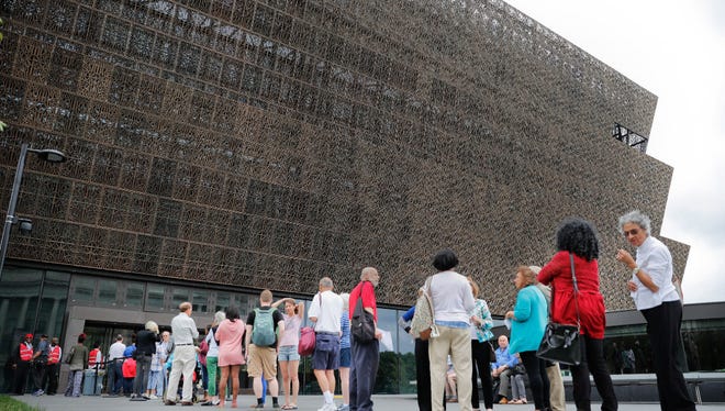 In this photo from May, people wait in line to enter the Smithsonian National Museum of African American History and Culture on the National Mall in Washington.