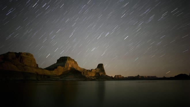 Jud appear to streak through the night sky above Gunsight Butte in Glen Canyon National Recreation Area in a long exposure image taken at Lake Powell. Stars appear to streak through the night sky above Gunsight Butte in Glen Canyon National Recreation Area in a long exposure image taken at Lake Powell.