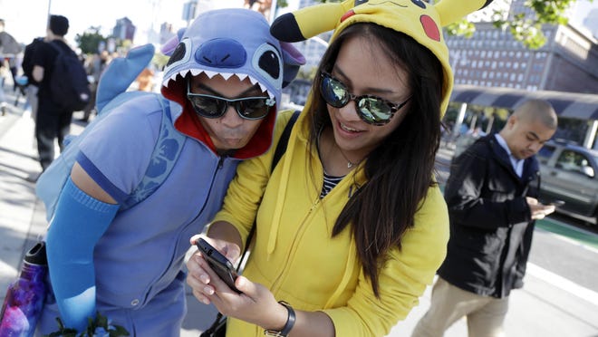 People costumed as the game's characters participate in a Pokemon Go search during a gathering of players Wednesday, July 20, 2016, in San Francisco.