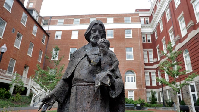 A Jesuit statue is seen in front of Freedom Hall, formerly named Mulledy Hall, on the Georgetown University campus, Thursday, Sept. 1, 2016, in Washington.