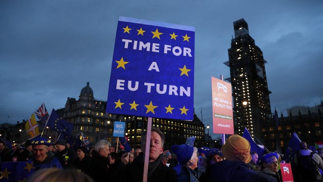Pro-European demonstrators hold posters at Parliament Square in London, Jan. 15, 2019.