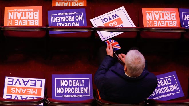 Attendees take their seats covered in placards at a political rally entitled 'Lets Go WTO' hosted by pro-Brexit lobby group Leave Means Leave in London on Jan. 17, 2019.