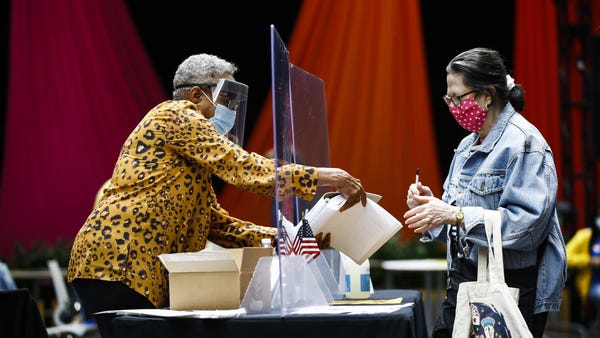 A voter, right, checks in with an election worker 