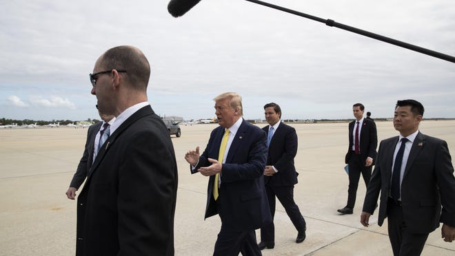 President Donald Trump walks to greet supporters upon arrival at the Orlando Sanford International Airport, Monday, March 9, 2020 in Orlando, Fla.