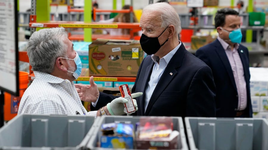President Joe Biden talks with a volunteer at the Houston Food Bank on Friday.