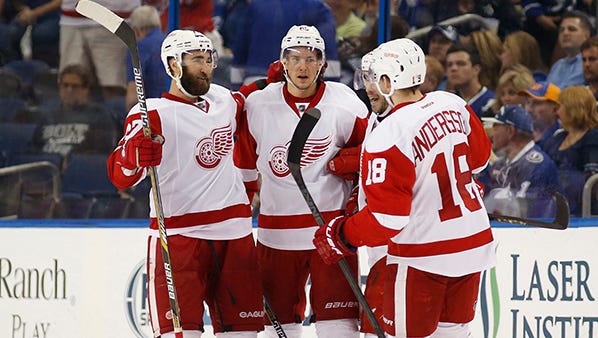 From left, Kyle Quincey and Danny DeKeyser gather with teammates after Detroit's first goal, by Riley Sheahan, on Saturday.